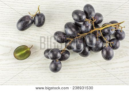 Black Grape Cluster (autumn Royal Variety) With One Sliced Berry Table Top Isolated On Grey Wood Bac