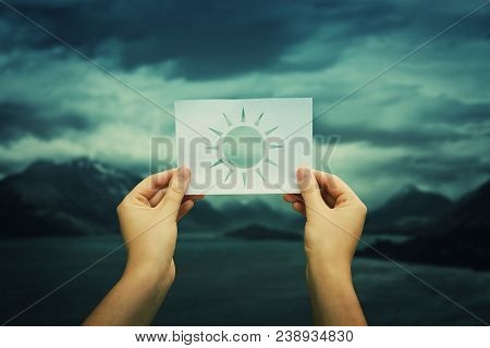 Close Up Of Woman Hands Holding A White Paper Sheet With A Sun Icon Over A Cold Background With The 