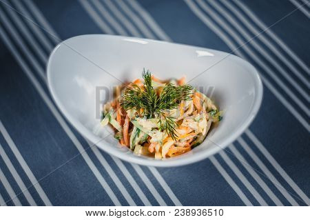 Top View Of A Salad In The White Plate On The Table With A Blue Tablecloth In White Strips. Salad Of