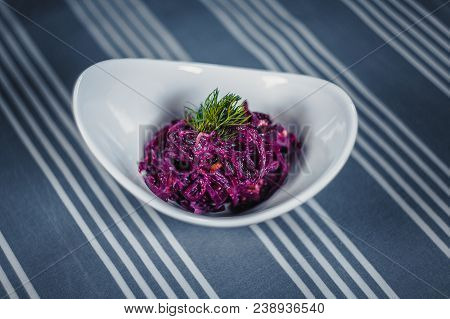 Top View Of A Salad In The White Plate On The Table With A Blue Tablecloth In White Strips. Salad Fr