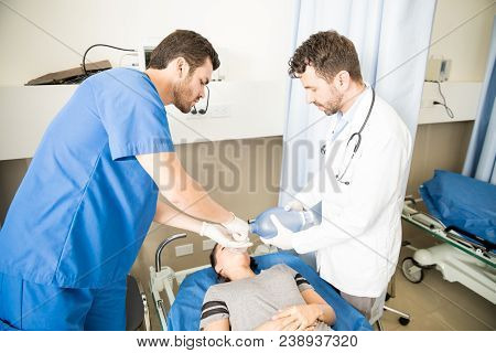 Two Paramedics Doing A Cardiopulmonary Resuscitation Using A Ambu Bag On Unconscious Female Patient