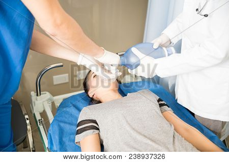 Close Up Of Doctors Using An Ambu Bag For Ventilation On Unconscious Patient In Emergency Room