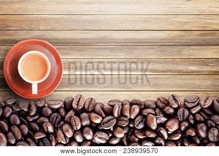 Top View With Roasted Coffee Beans And Coffee Cup On Wood Table Background Area For Copy Space. Coff
