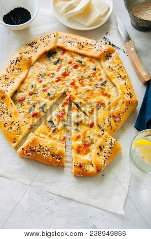 Arabic And Middle Eastern Food Concept. Cheese And Labneh Savory Galette With Olives On A Baking Pap