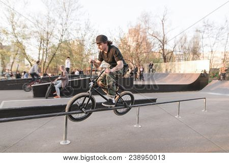 Bmx Rider Performs A Trick On A Skate Park. Training On Bmx. Bmx Concept. Slip On Bmx On Railings