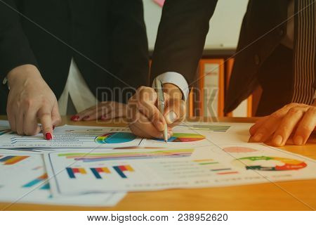 Female Pointing On Ducument Charts With Male Hand Writing During Meeting In The Office, Business Tea