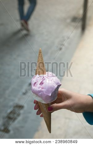 A Woman Sitting And Holding An Ice Cream. Summer Time In The Street Of The Old City