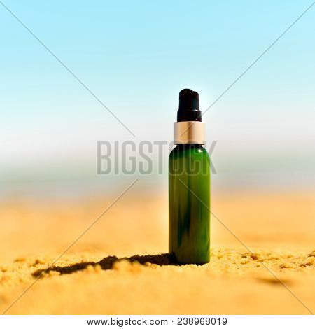 Bottle Of Sunscreen In Sand Against Sea Background With Copyspace. Vacation And Travel Wallpaper. Sk