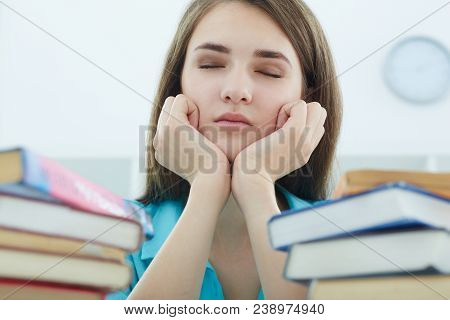 Tired Female Student At Workplace In Room Taking Nap On Pile Of Textbooks. Sleepy Brunette Woman Res