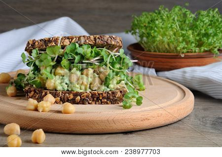 Sandwich Of Rye Bread With Cereals With Crushed Avocado, Chickpeas And Sprouts Of Radish Shoots.
A G