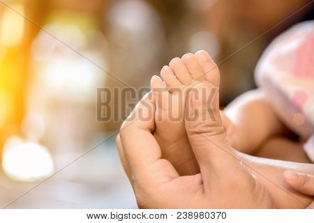 Babies Bare Feet In Moms Hands Close Up Photo