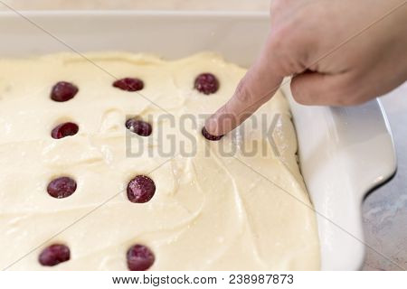 A Woman Is Adding Frozen Cherries To A Pie. Raw Cake Decorated With Frozen Cherry Close-up