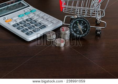 Caculator , Stack Of Coins , Shopping Trolley And Compass With Copay Space
