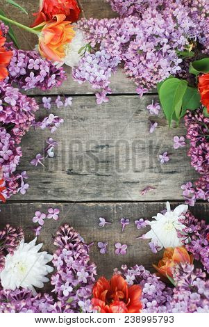Tulips And Lilac Frame Over Rustic Textured Wooden Board Isolated