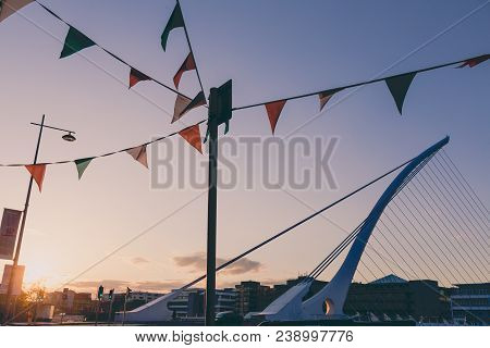 View Of Dublin's Famous Samuel Beckett Bridge Over The River Liffey At Sunset