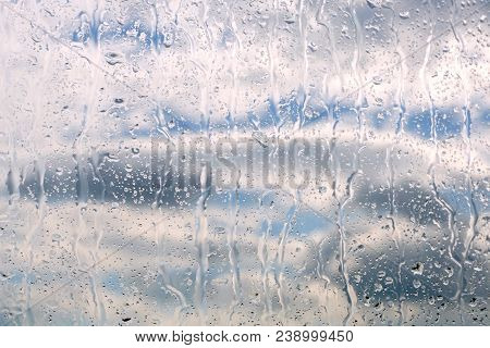 Raindrops On Glass, Storm Clouds In The Background. Weather Forecast. Abstract Spring Weather Backgr
