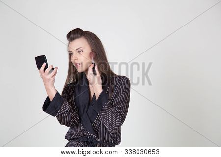Girl In Coat Makes Brush Makeup Looks In The Mirror