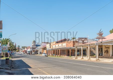 Vrede, South Africa - May 1, 2019: A Street Scene, With Businesses And Vehicles, In Vrede, In The Fr