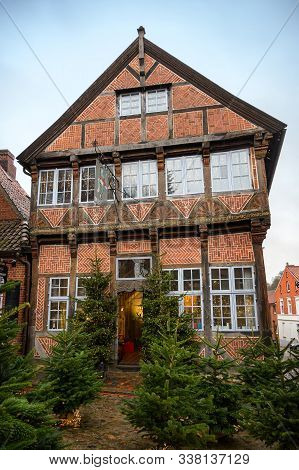Moelln, Germany - December 7, 2019: Old Crooked Half-timbered House Decorated With Fir Trees In Fron