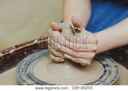 Woman Hands On Pottery Wheel, Potter At Work. Craftsman Artist Shapes Pot