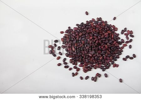 A Slide Of Red Raw Beans Sprinkled On A White Background. Healthy Lifestyle. Copy Spaes
