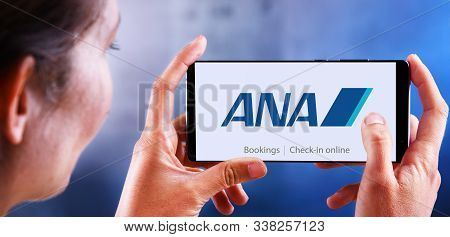 Poznan, Pol - Dec 08, 2019: Woman Holding Smartphone Displaying Logo Of All Nippon Airways Co., Also