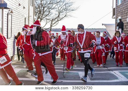 Mattapoisett, Massachusetts, Usa - December 7, 2019: Cluster Of Santas Making Turn At Start Of Matta