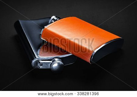Flasks For Alcohol Are On The Table. Steel Flasks With Leather Trim On A Black Background. Tanks For