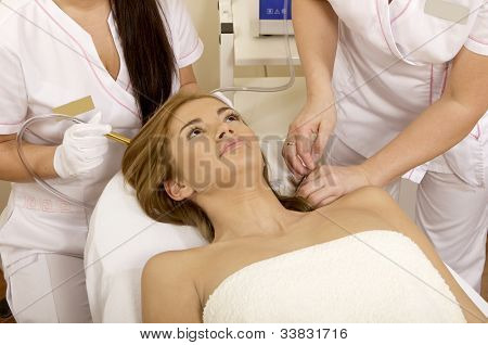 Mladá bruneta žena přijímá laserové terapie. Wellness studio zastřelil