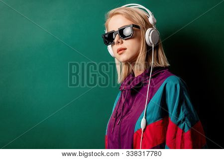 Style Woman In Sunglasses With Headphones On Aqua Menthe Color Background