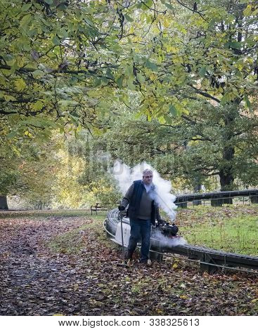 Maidstone Kent, Uk, November 2019 - A Miniature Steam Train With The Driver Walking Alongside In Mot