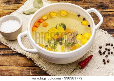 Transparent Duck Broth With Dumplings And Vegetables. Traditional Bouillon, Healthy Food. Old Wood B