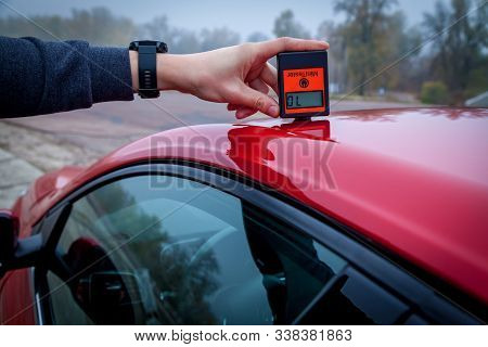 Measuring The Thickness Of The Car Paint Coating In Black Color Using A Paint Thickness Gauge.