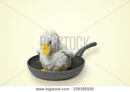 Cute Fluffy Toy Chicken On A Frying Pan. Cruel Meat Industry, Poultry Consumption Concept