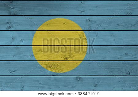 Palau Flag Depicted In Bright Paint Colors On Old Wooden Wall. Textured Banner On Rough Background