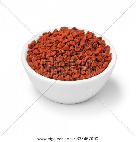 Bowl with dried whole Annatto seeds close up isolated on white background