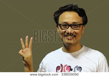 A Smiling And Confident Manipuri North East Indian Man With Spectacles Showing The Sign Of Three Wit