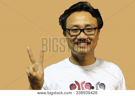 A Smiling And Confident Manipuri North East Indian Man With Spectacles Showing The Sign Of Two And V