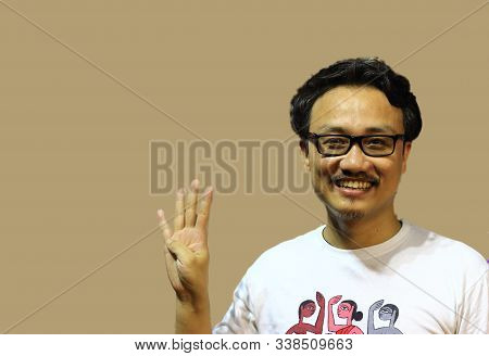 A Smiling And Confident Manipuri North East Indian Man With Spectacles Showing The Sign Of Four With
