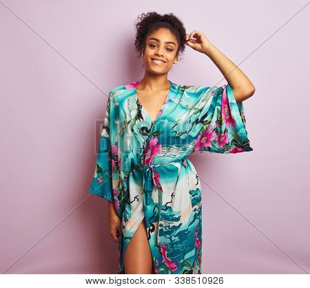 Young beautiful african american woman standing wearing elegant colorful caftan
