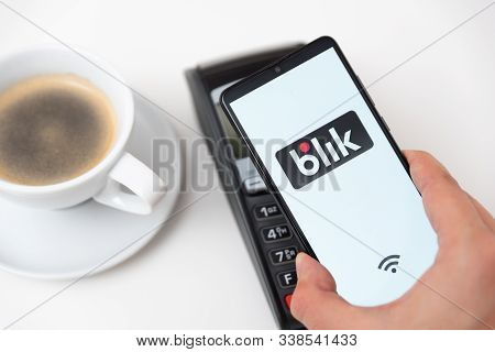 Wroclaw, Poland - Nov 06, 2019: Man Holding Smartphone With Blik Logo, Contactless Payment. Blik Is 