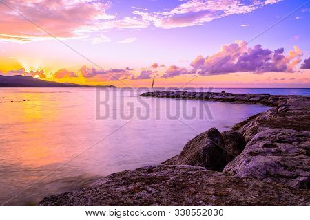 Magnificent Sunset With Colorful Sky Colors As Sun Sets Behind Mountains On Tropical Caribbean Islan