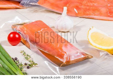 Red Fish In A Sealed Vacuum Plastic Bag On The Background Of A Stack Of Packages. Finished Product