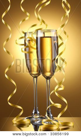 glas champagne og streamer på gul baggrund