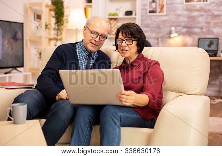 Elderly Old Couple Using Modern Laptop To Chat With Their Grandson