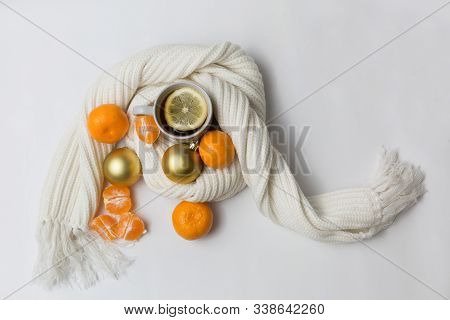 Lemon Tea Is Wrapped In A White Knitted Scarf On A White Background With Tangerines And Christmas Go