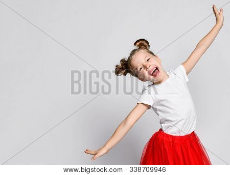Singing Laughing Kid Girl In Red Fatin Skirt And White T-shirt Is Posing Holding Her Hands Diagonal 