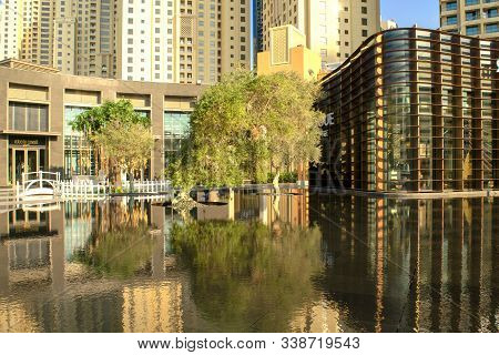 Dubai/uae - November 11, 2019: View Of Jbr Artificial Water Pond With Green Trees In The Middle. Jum
