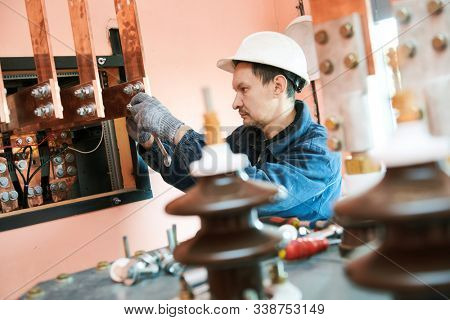Electrician lineman worker installing power industrial transformer