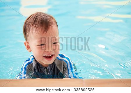 Cute Little Asian 2 Years Old Toddler Boy Child On The Edge Of A Swimming Pool, Little Kid Takes A S